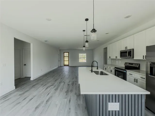 a kitchen with sink a microwave and refrigerator