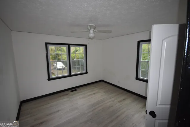 an empty room with windows and closet