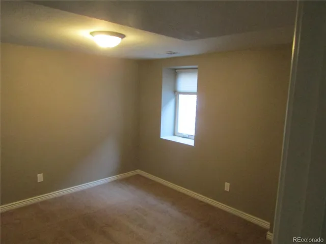 an empty room with a fan and a window