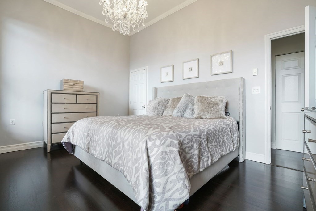 100 Captains Row, Unit 301 Chelsea, MA 02150 - Photo 11 of 23 a bedroom with a bed and a chandelier