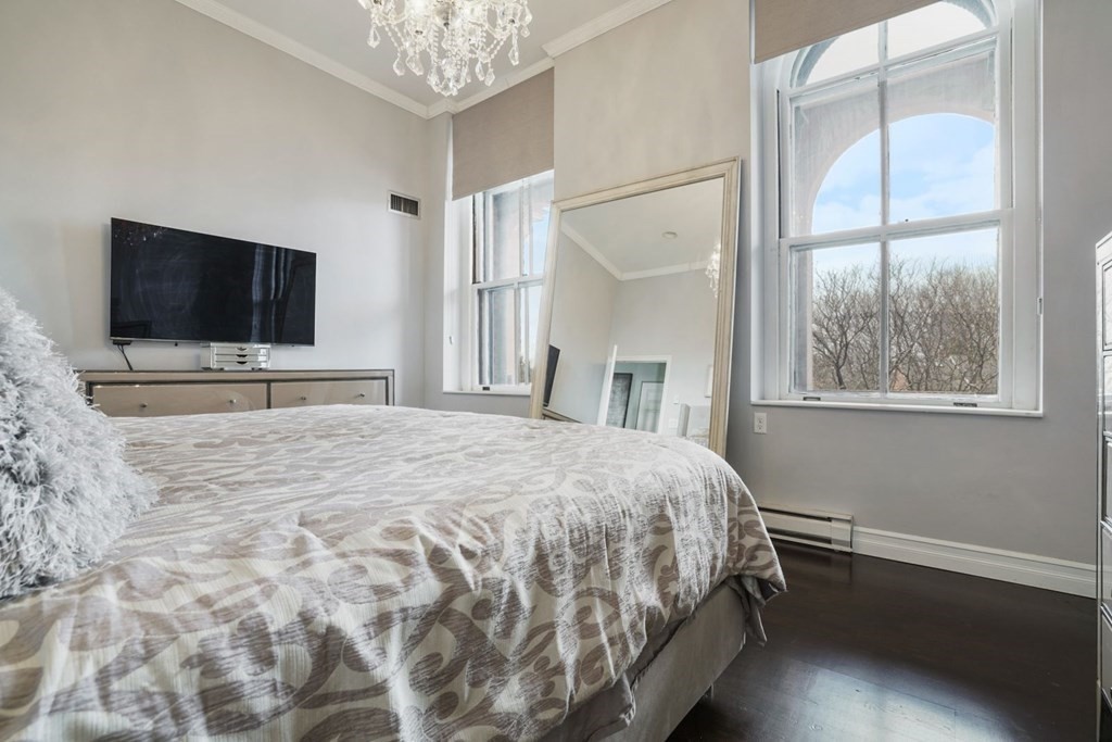 100 Captains Row, Unit 301 Chelsea, MA 02150 - Photo 13 of 23 a bedroom with a bed and a flat screen tv