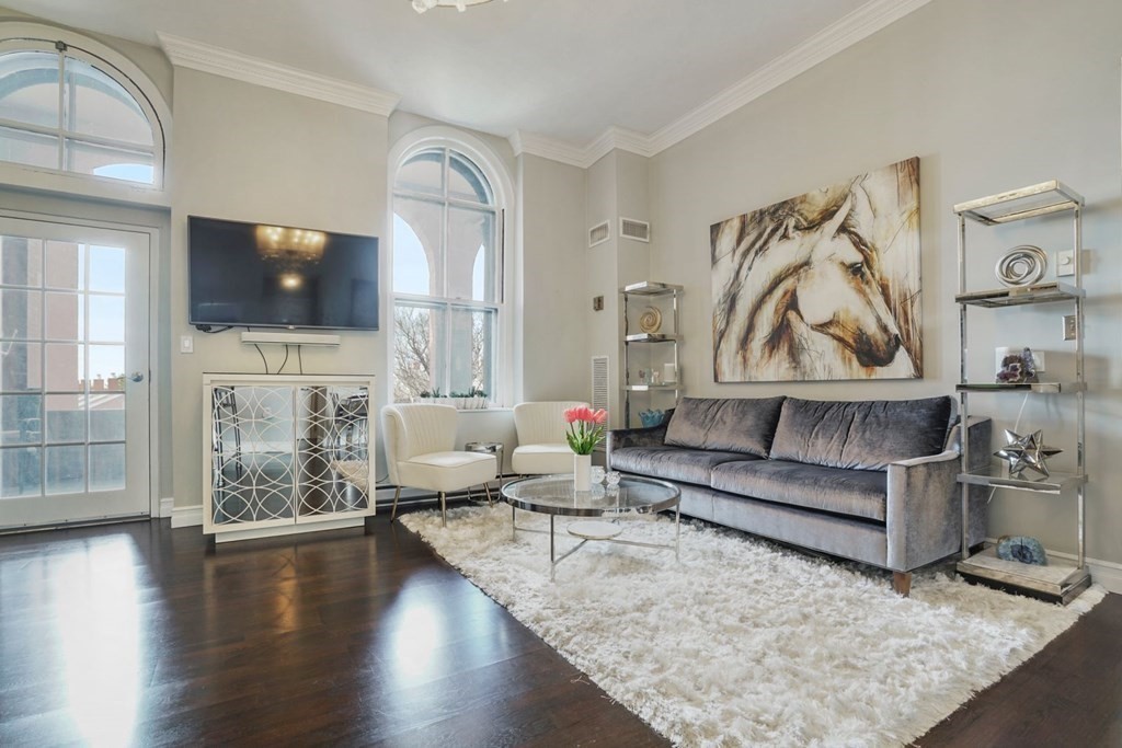 100 Captains Row, Unit 301 Chelsea, MA 02150 - Photo 5 of 23 a living room with fireplace furniture and a flat screen tv