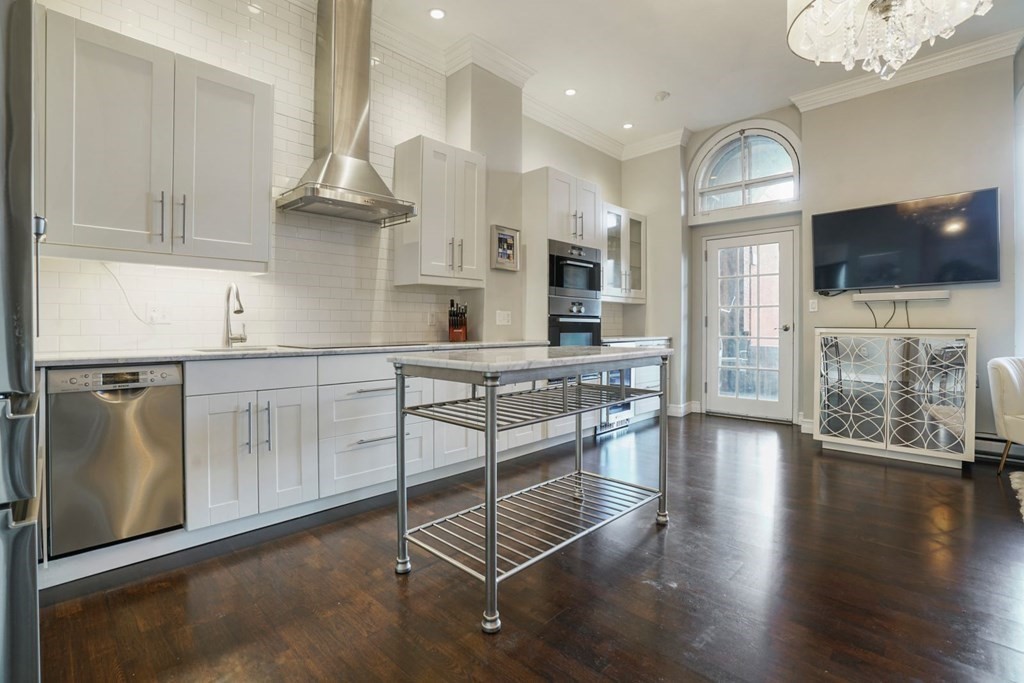 100 Captains Row, Unit 301 Chelsea, MA 02150 - Photo 7 of 23 a kitchen with stainless steel appliances granite countertop a stove a sink and a refrigerator