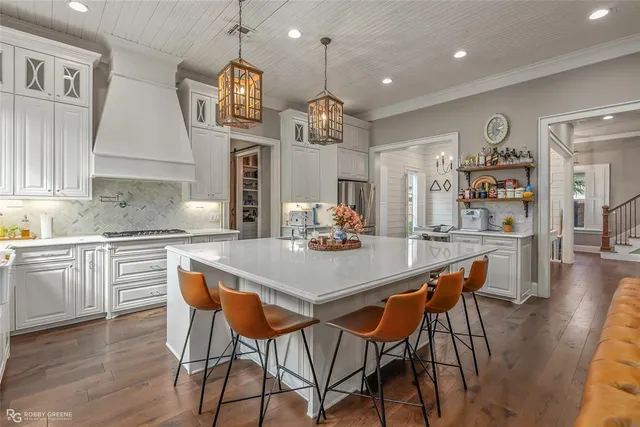 a kitchen with stainless steel appliances kitchen island granite countertop a dining table chairs and granite counter tops