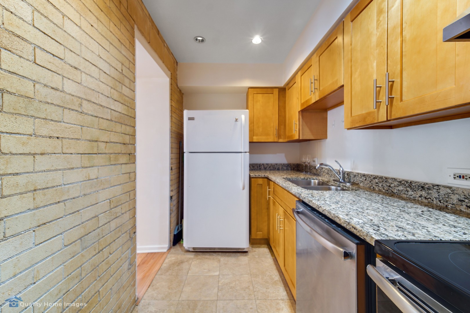 40 East 9th Street, Unit 405 Chicago, IL 60605 - Photo 7 of 18 a kitchen with a sink a refrigerator and cabinets