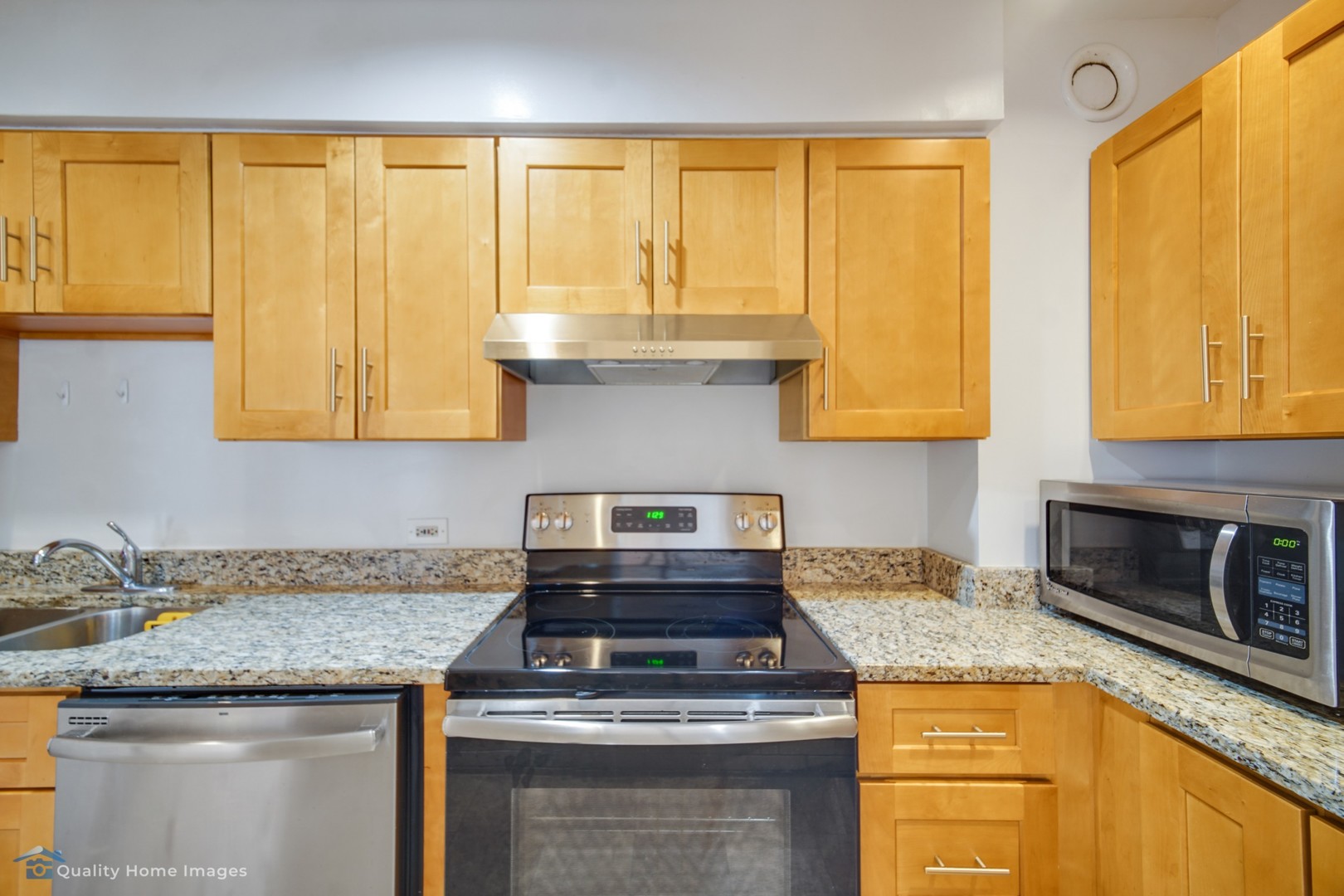 40 East 9th Street, Unit 405 Chicago, IL 60605 - Photo 8 of 18 a kitchen with granite countertop a sink a stove and cabinets