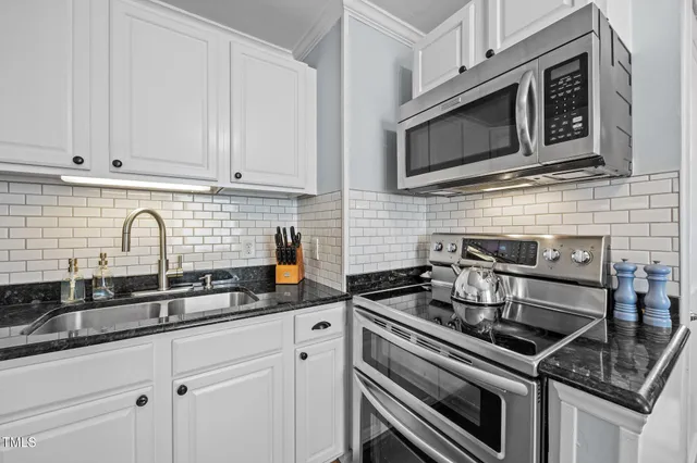 a kitchen with stainless steel appliances granite countertop a refrigerator a stove and a dining table with wooden floor