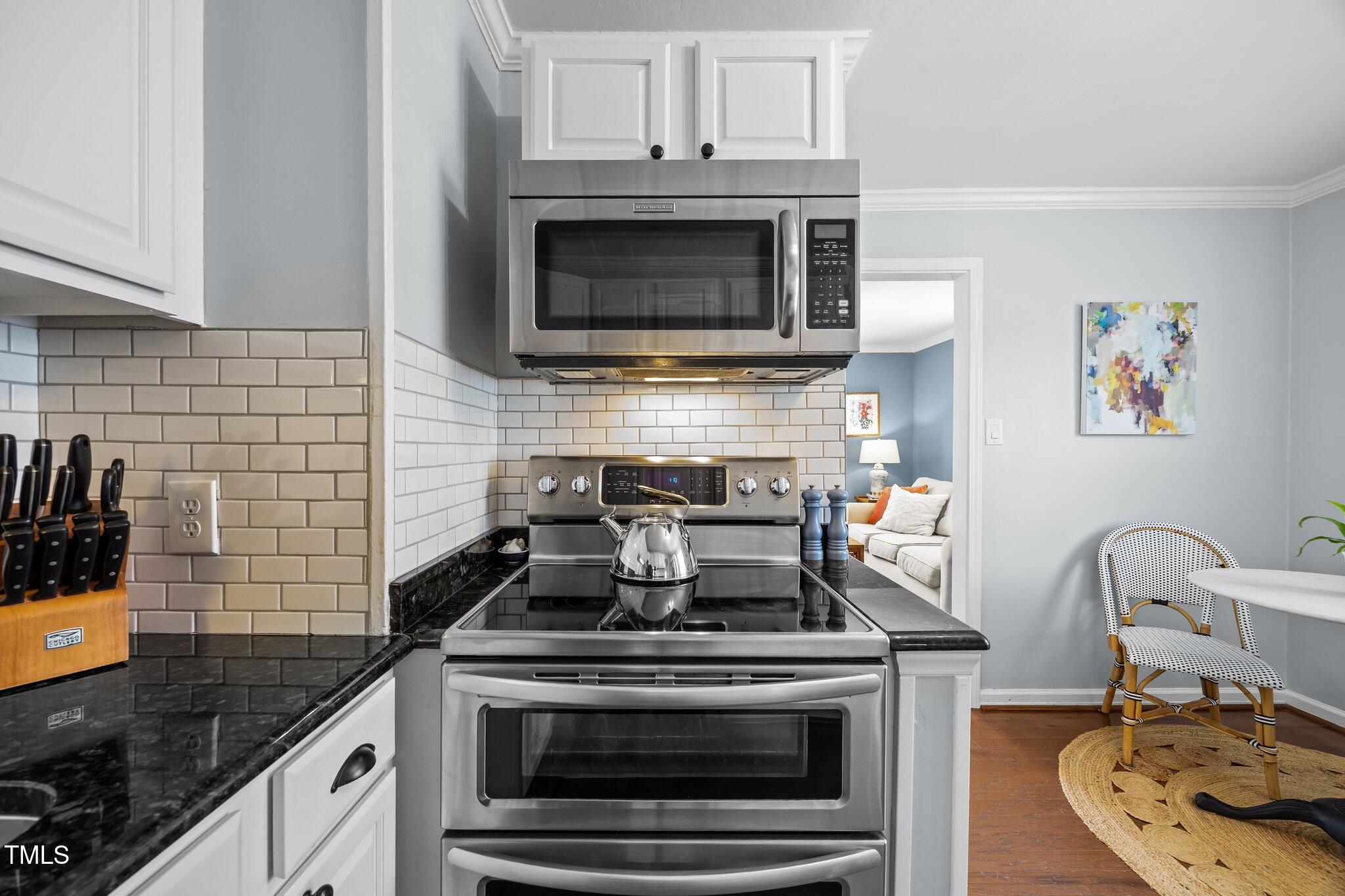711 New Road Raleigh, NC 27608 - Photo 16 of 54 a kitchen with granite countertop a stove and a sink