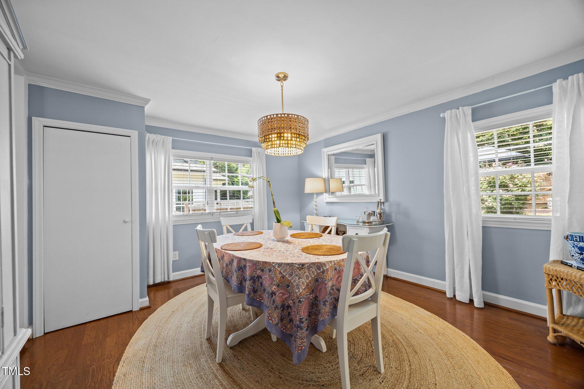 711 New Road Raleigh, NC 27608 - Photo 18 of 54 a dining room with furniture a chandelier and wooden floor
