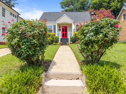 a front view of a house with a yard and flower plants