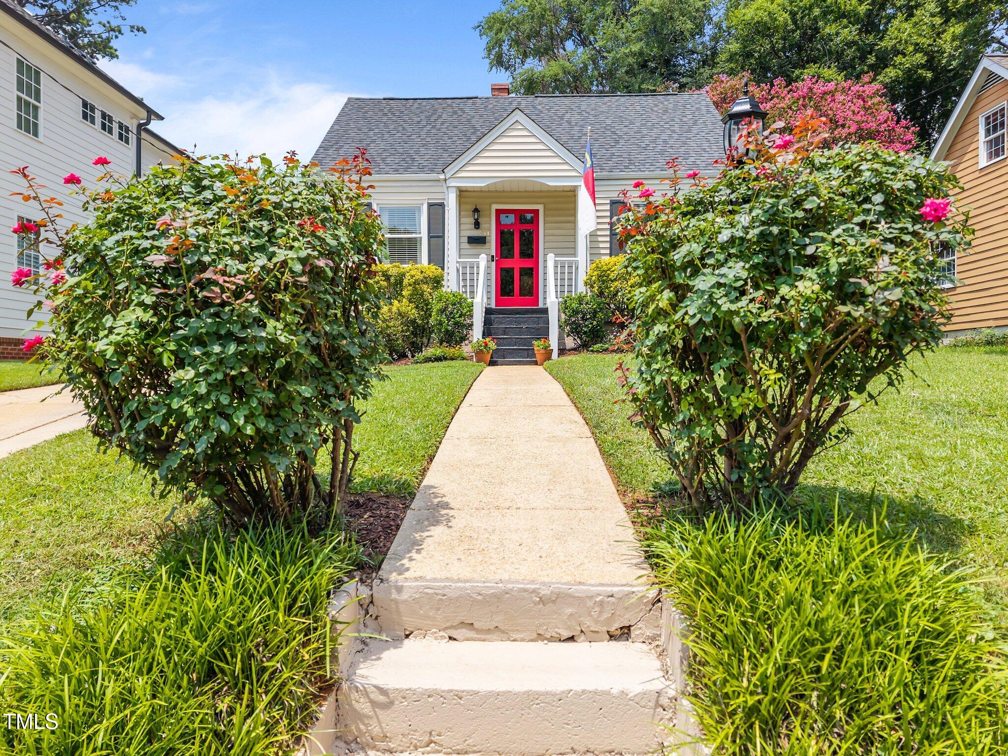 711 New Road Raleigh, NC 27608 - Photo 2 of 54 a front view of a house with a yard and flower plants