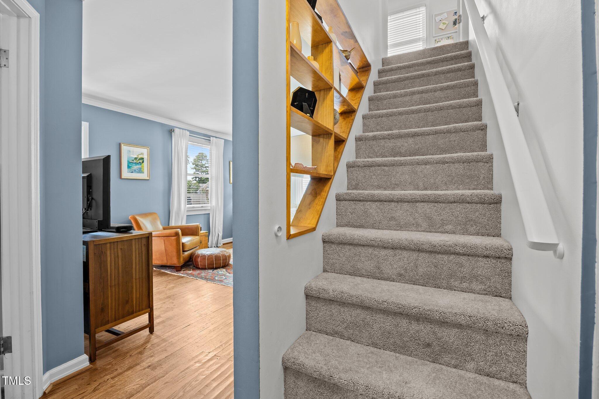 711 New Road Raleigh, NC 27608 - Photo 26 of 54 a view of staircase with lots of frames on wall and a large window
