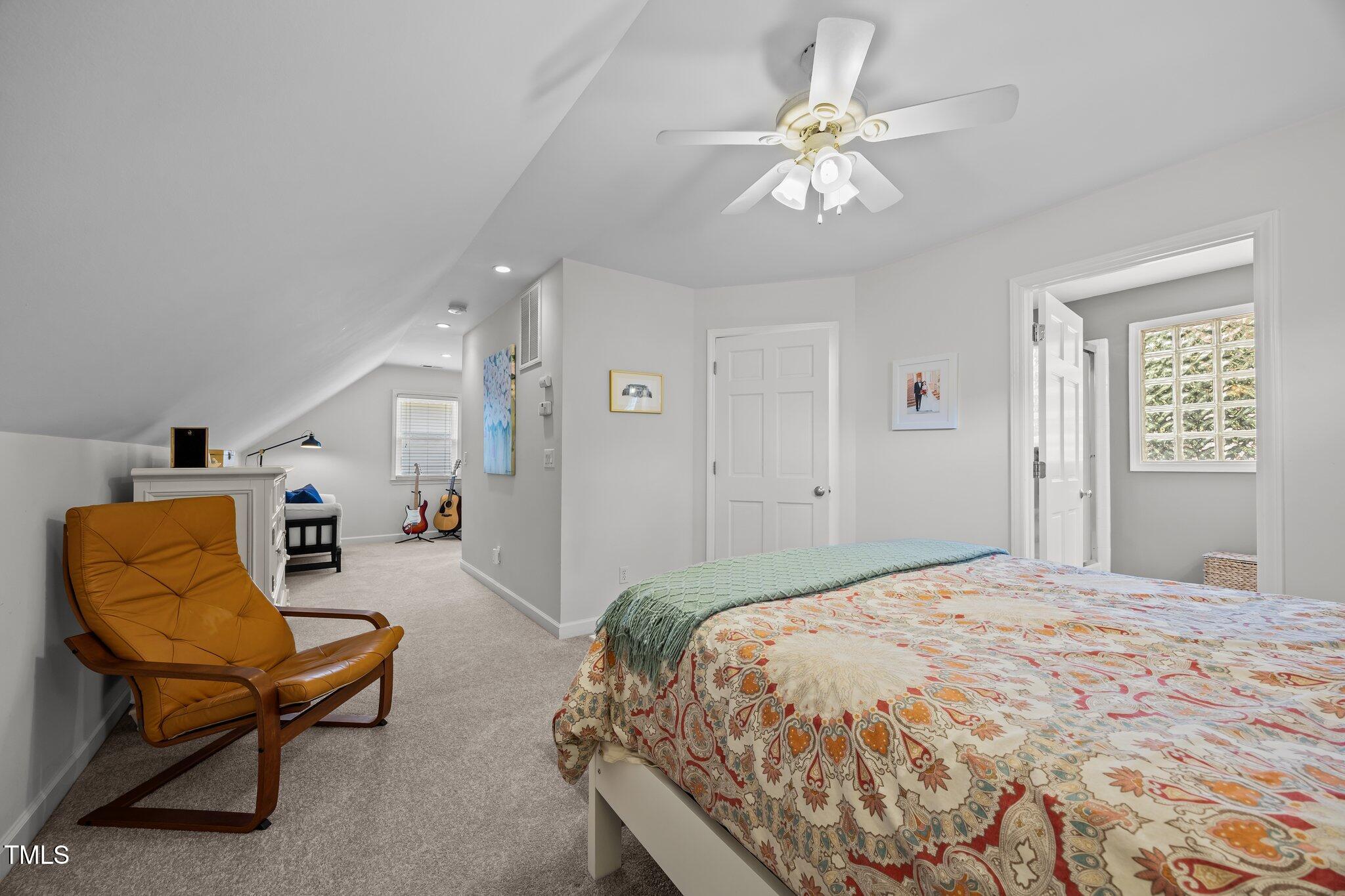 711 New Road Raleigh, NC 27608 - Photo 29 of 54 a spacious bedroom with a bed and a chandelier