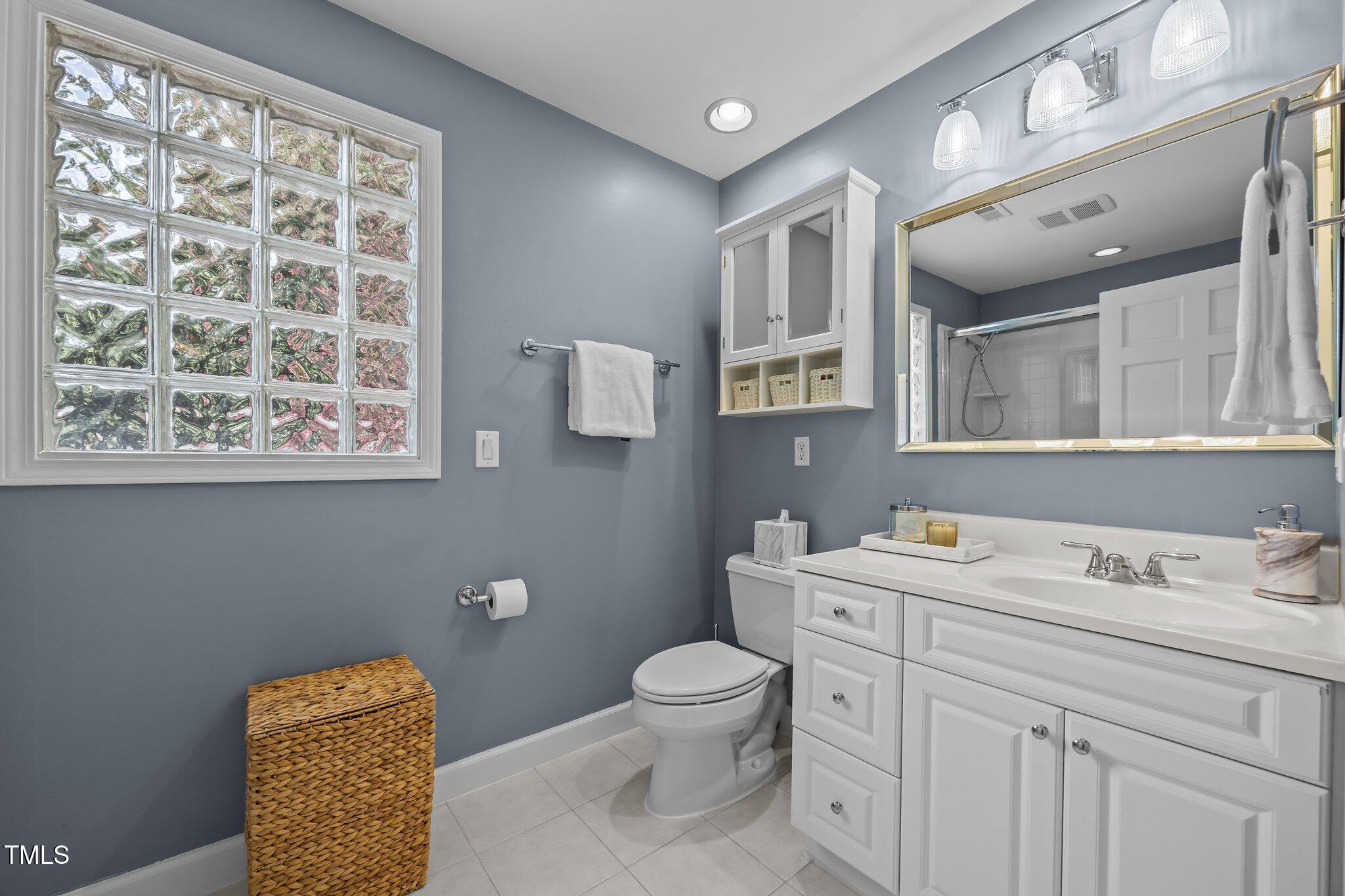 711 New Road Raleigh, NC 27608 - Photo 30 of 54 a bathroom with a toilet a sink and mirror