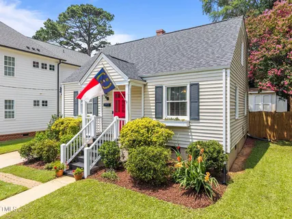 a view of a house with a yard and potted plants