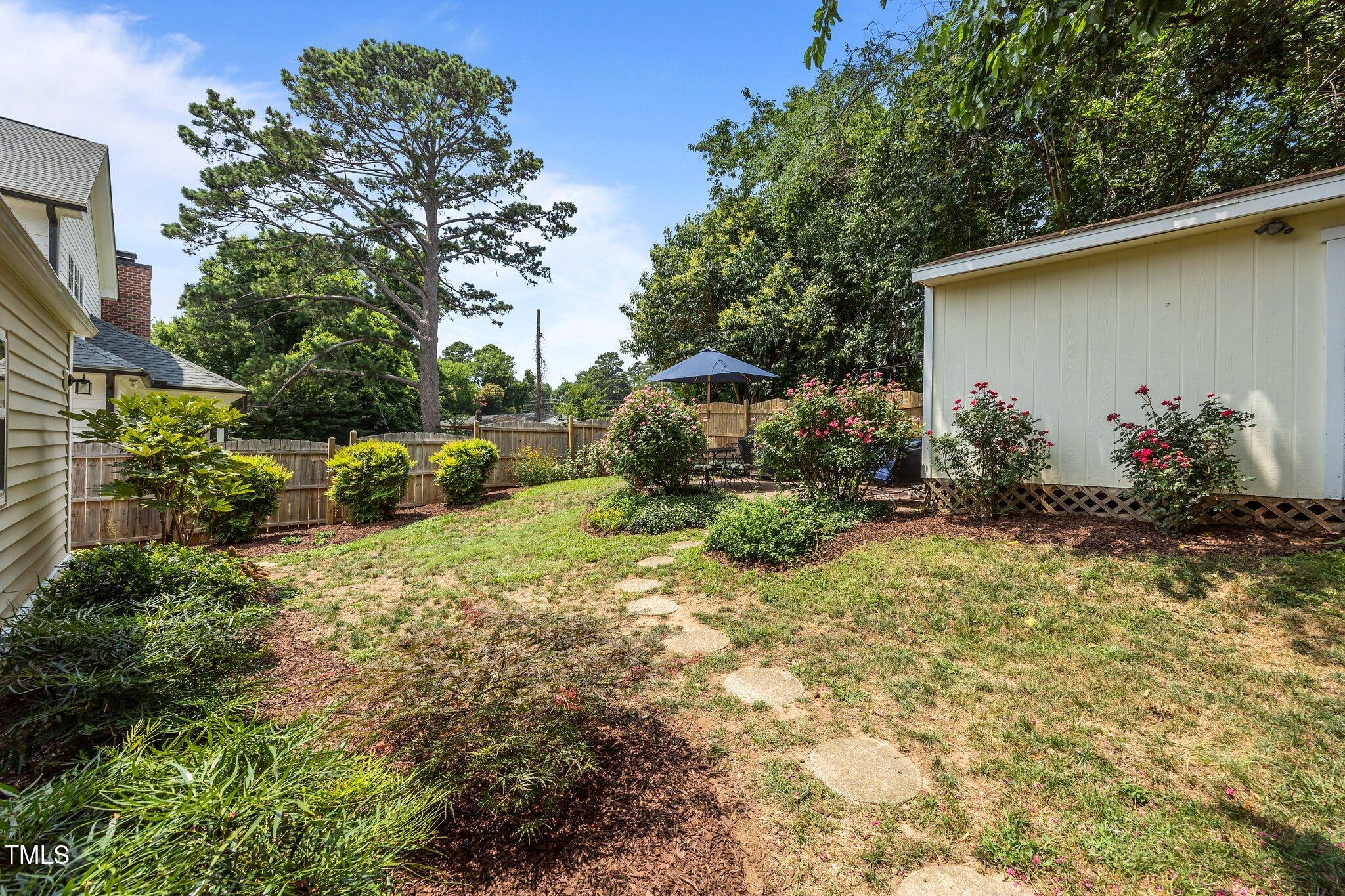 711 New Road Raleigh, NC 27608 - Photo 34 of 54 a backyard of a house with flower plants