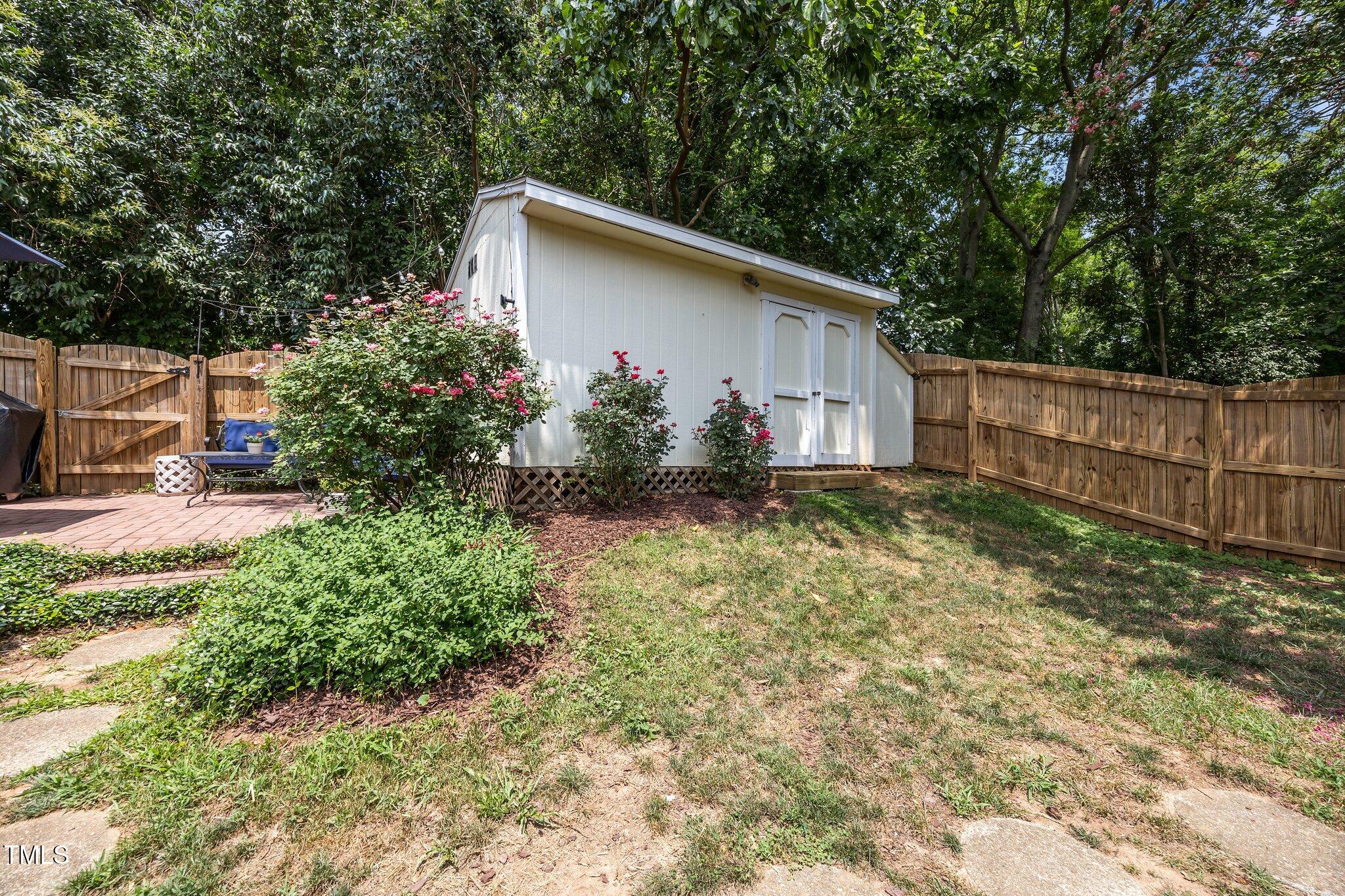 711 New Road Raleigh, NC 27608 - Photo 35 of 54 a backyard of a house with wooden fence and large trees
