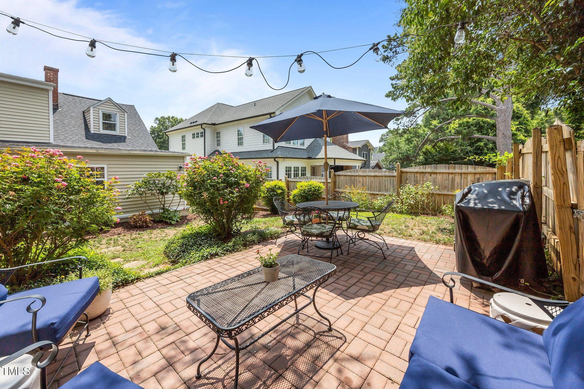 711 New Road Raleigh, NC 27608 - Photo 36 of 54 a view of a patio with table and chairs under an umbrella