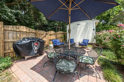 a view of a patio with table and chairs potted plants with wooden fence