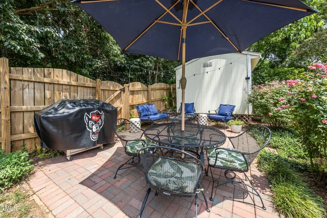 a view of a patio with table and chairs potted plants with wooden fence
