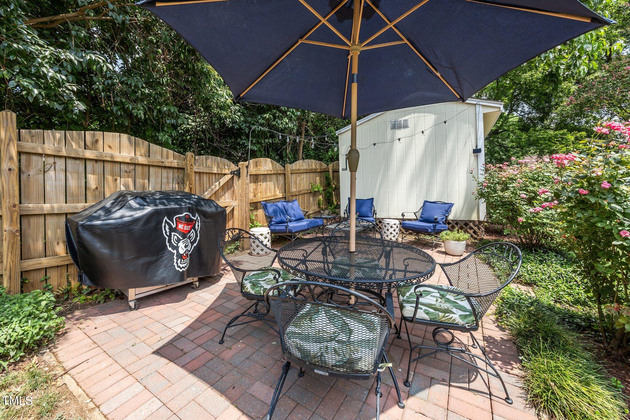 711 New Road Raleigh, NC 27608 - Photo 37 of 54 a view of a patio with table and chairs under an umbrella