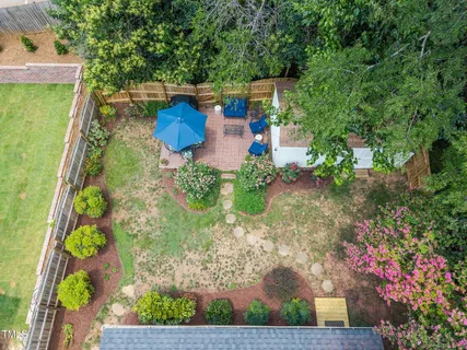 an aerial view of a house with swimming pool and large trees
