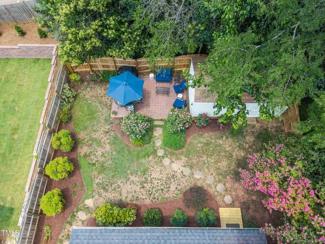 an aerial view of a house with swimming pool and large trees