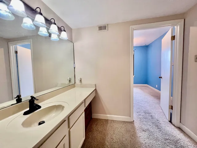 a view of a big room with windows and chandelier