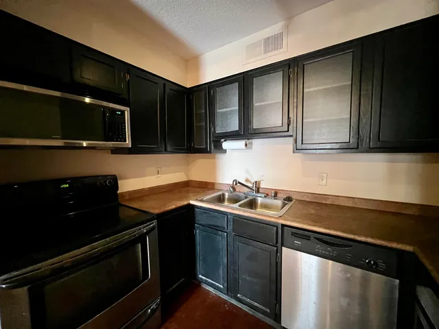 a kitchen with a sink and a stove top oven