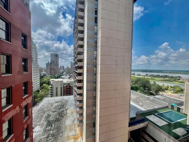 a view of balcony with a couple of cars parked in parking lot