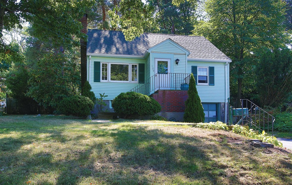 a front view of a house with yard and trees