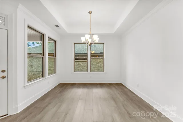 a view of a room with wooden floor exposed radiator and windows