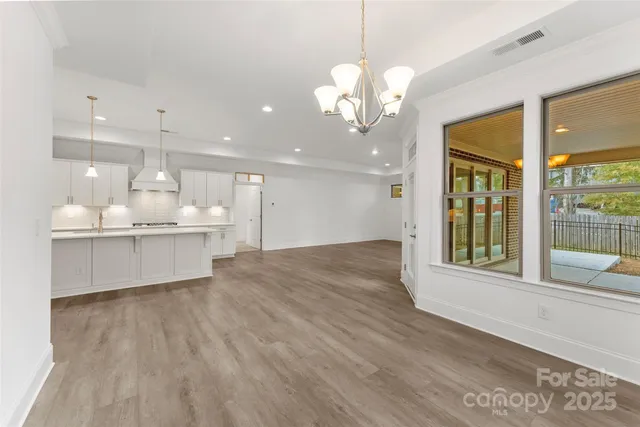 a large kitchen with a large window wooden floor and stainless steel appliances