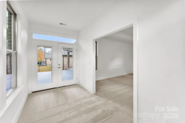 an empty room with windows and entrance