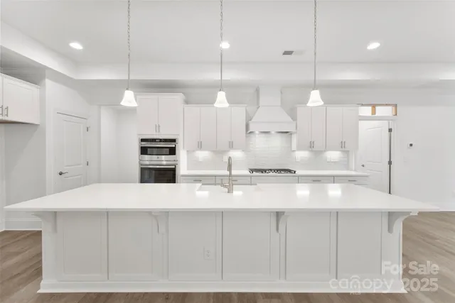 a large white kitchen with a refrigerator a sink and a stove