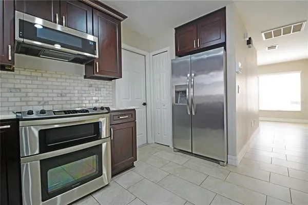 a kitchen with stainless steel appliances granite countertop a refrigerator and a sink