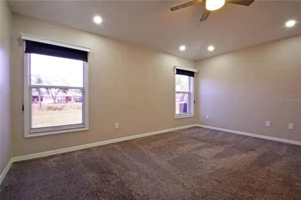 an empty room with fan and entrance