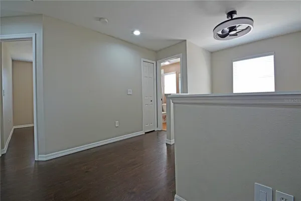 a view of an empty room with wooden floor