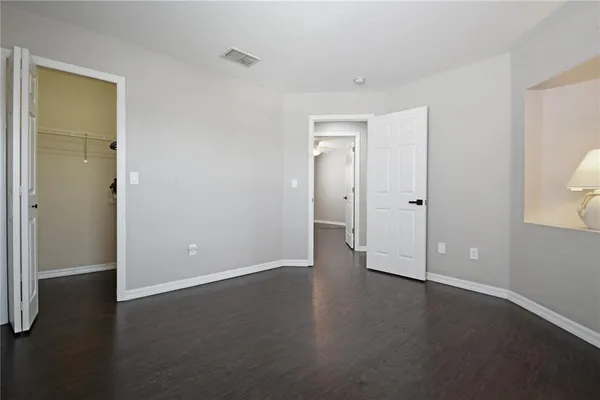 a bathroom with a granite countertop toilet a sink and a mirror