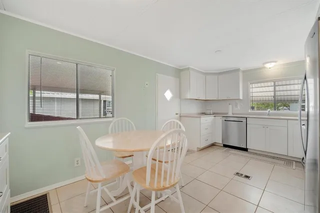 a kitchen with a stove a sink and white cabinets