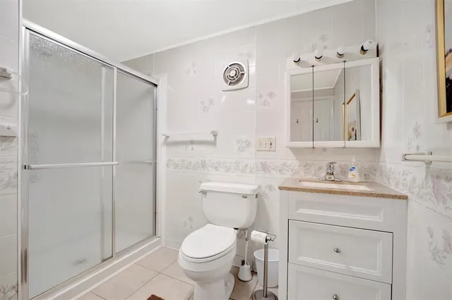 a bathroom with a toilet a sink a glass door and shower