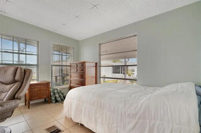 a bedroom with a bed couch and a large window