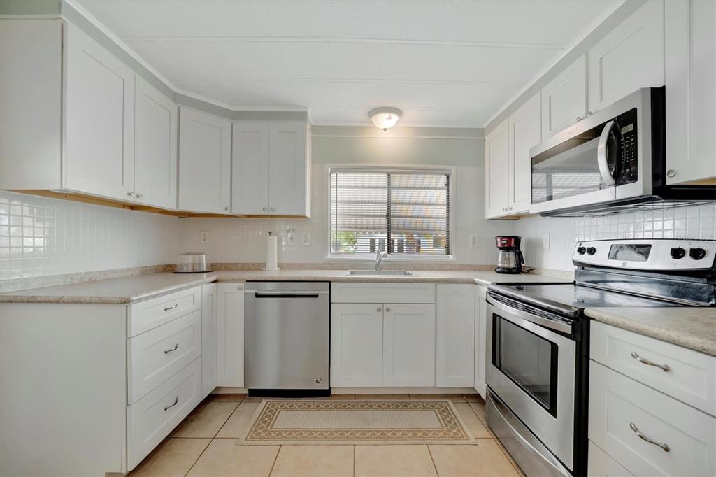 110 East St Lucia Loop Apollo Beach, FL 33572 - Photo 2 of 35 a kitchen with granite countertop white cabinets stainless steel appliances and a sink