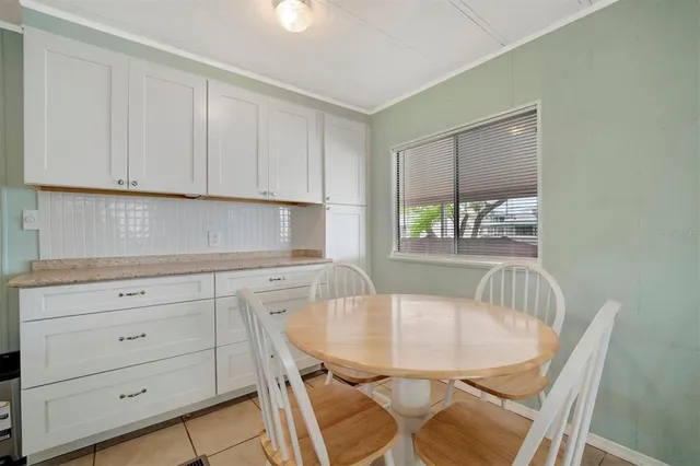 a kitchen with a table chairs cabinets and a window