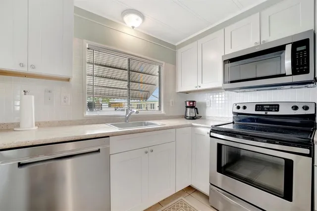 a kitchen with stainless steel appliances a stove microwave and sink