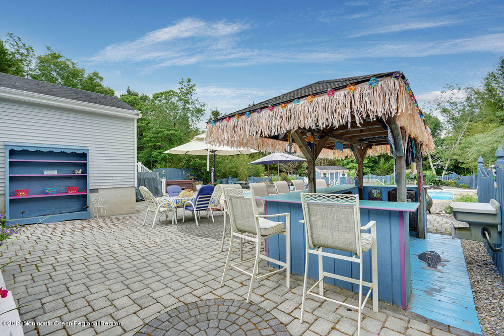 205 Forge Road West Creek, NJ 08092 - Photo 54 of 64 a view of patio with a table and chairs under an umbrella