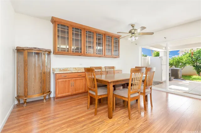 a dining room with wooden floor a chandelier a glass table and chairs