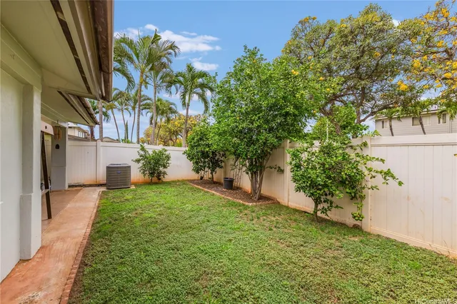 a view of a yard in front of a house with a large tree