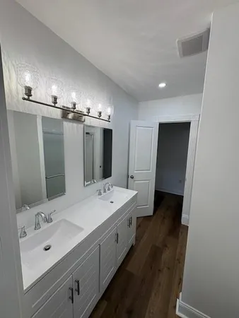 a spacious bathroom with a double vanity sink and mirror