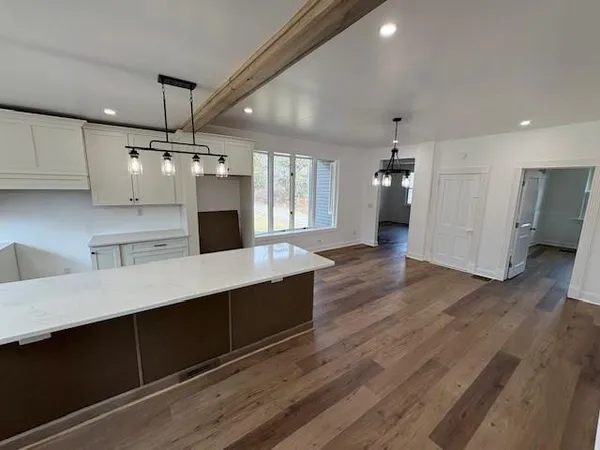 a large kitchen with a lot of counter space and wooden floor